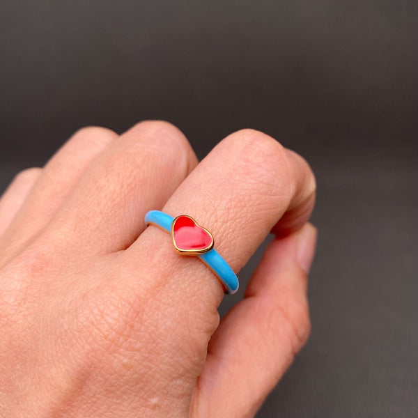18k gold plated stainless steel ring with thin enameled bright blue band and red heart face. Shown worn