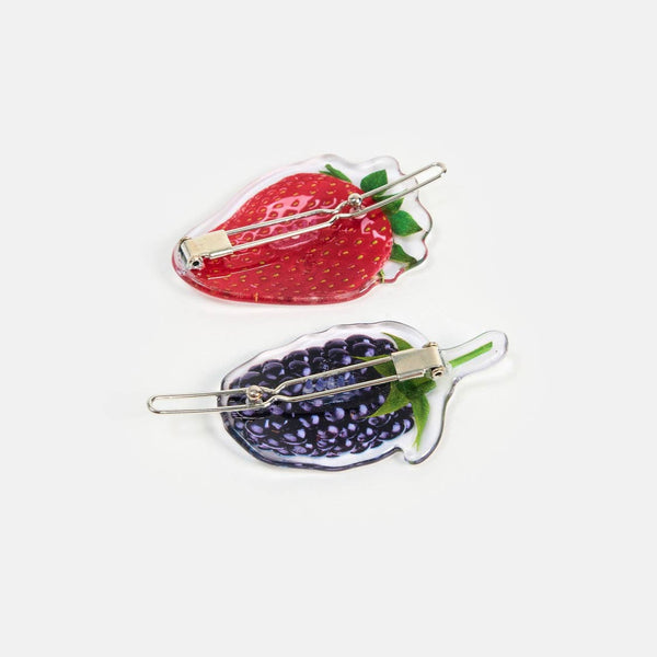 set of two acetate ball-and-clasp barrettes  with photorealistic strawberry and blackberry designs. Shown from back to display clip hardware