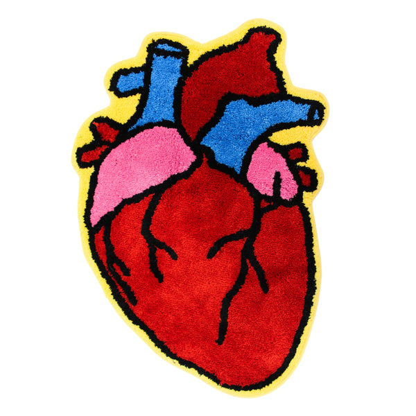 A colorful tufted rug shaped like a stylized anatomical heart, featuring red, pink, and blue sections outlined in black with a brifght yellow border, shown from the front on a plain white background.