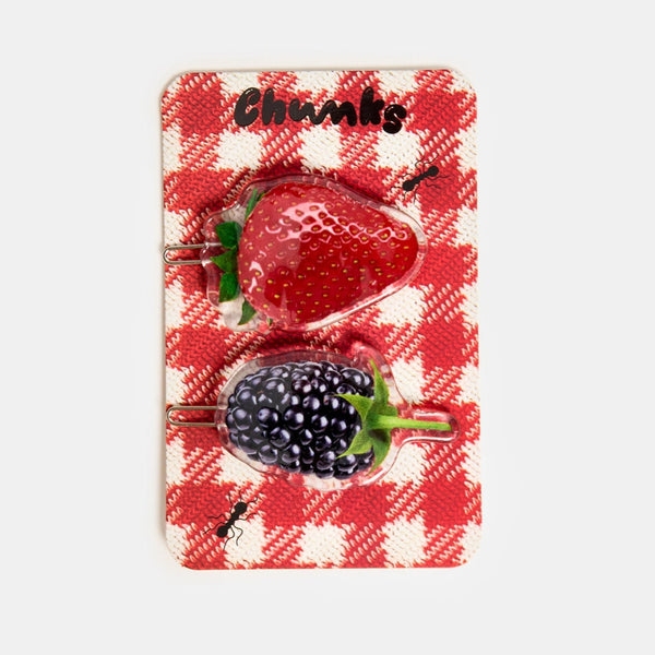 set of two acetate ball-and-clasp barrettes  with photorealistic strawberry and blackberry designs. Shown on red and white gingham backing card