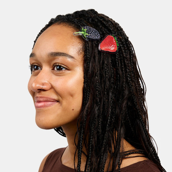 set of two acetate ball-and-clasp barrettes  with photorealistic strawberry and blackberry designs. Shown in model's hair