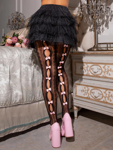 Model wearing striped black net pantyhose with heart knit-in detail and small baby pink satin bows running down the middle of the open peekaboo panels of each leg. Shown with the bows worn in the back
