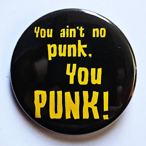 1.25" round pinback with bright yellow text "You ain't no punk, You PUNK!" on a black background