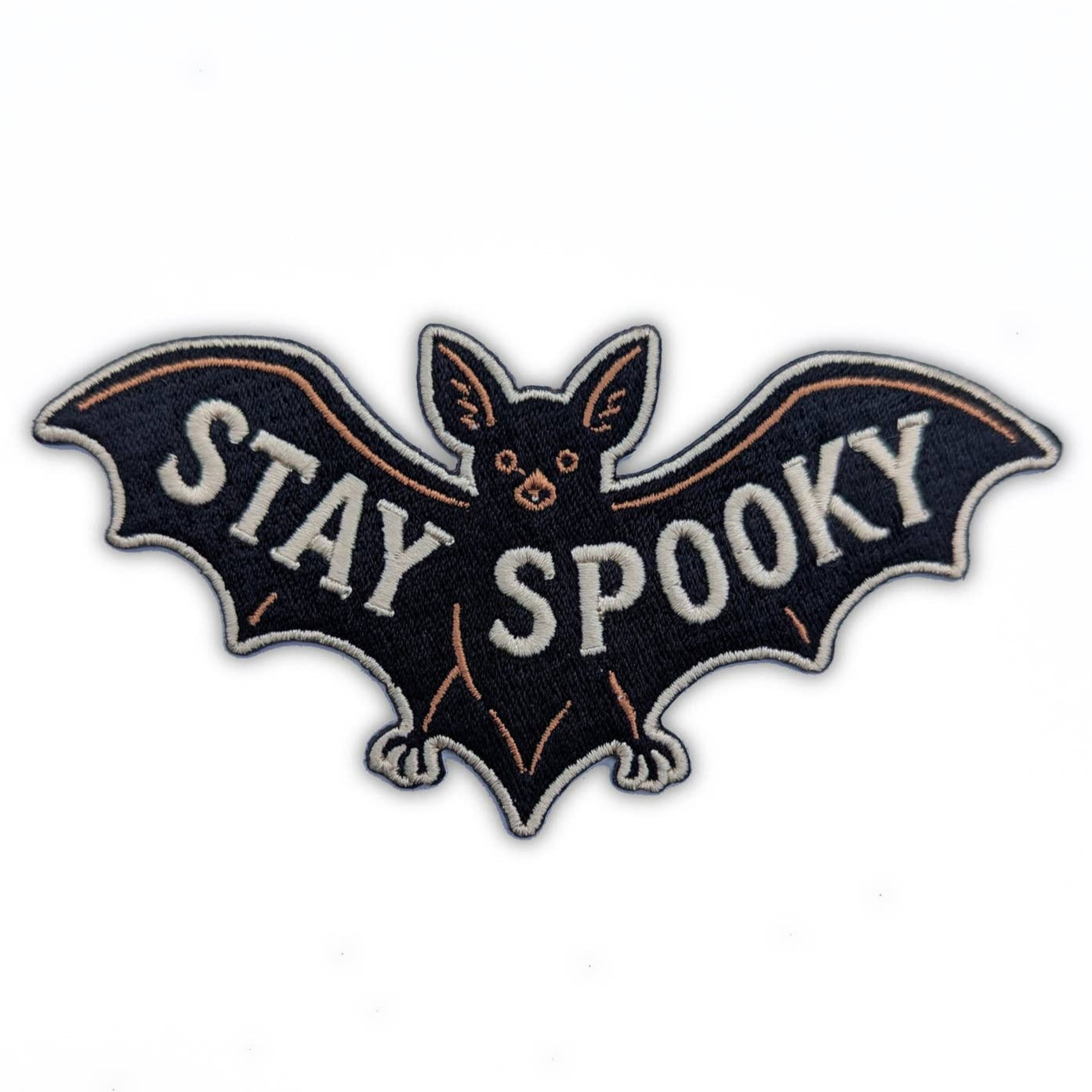 black embroidered patch with brown and white details of bat with outstretched wings and message "STAY SPOOKY" in white