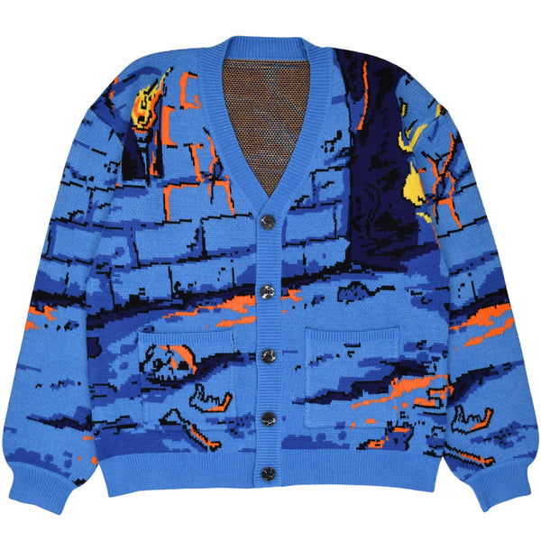 relaxed fit cardigan with jacquard knit pattern of 8-bit style pixelated dungeon design with bones, brick wall, and orange ooze on ground. Sweater has patch pockets, v-neckline, tortoiseshell buttons, and ribbed collar and cuffs. Shown from front 