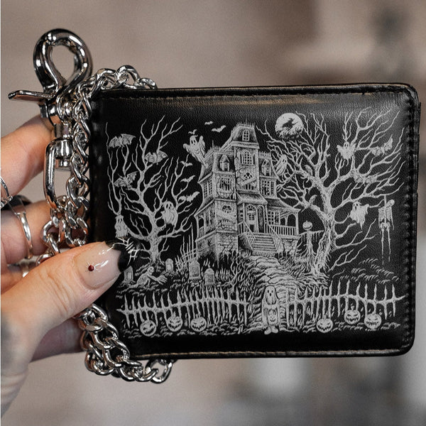 Black faux leather billfold style Waller with grey art of haunted house on exterior and wallet chain. Shown closed