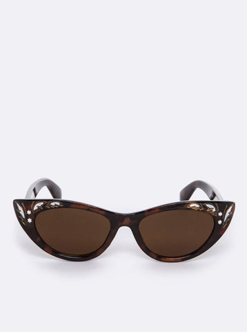 pair of shiny tortoiseshell retro cat eye sunglasses with beautiful carved leaf embellishments at the corner of each frame with painted gold and white detail and dark brown lenses