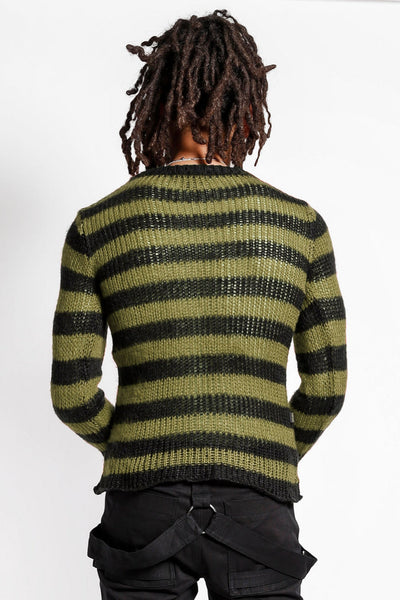 male model wearing a green and black striped long sleeve sweater with distressed detail on the front of the body on a white background. Shown from the back