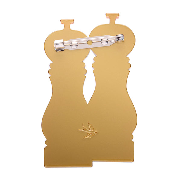 White and black layered acrylic resin pepper grinder set brooch with gold monogram on a white background, showing solid gold backing layer with silver metal pin clasp
