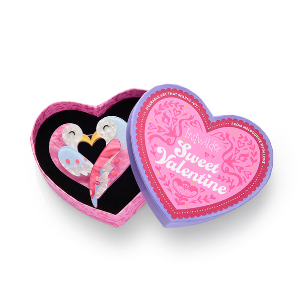 layered acrylic resin brooch depicting a pair of lovebirds in the shape of a heart, shown in illustrated heart-shaped box packaging