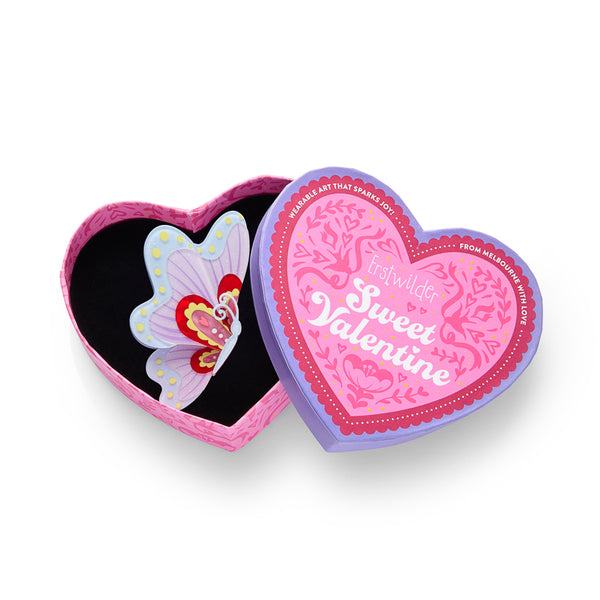 Colorful butterfly-shaped layered acrylic resin brooch with polka dot border, shown in illustrated heart-shaped box packaging 