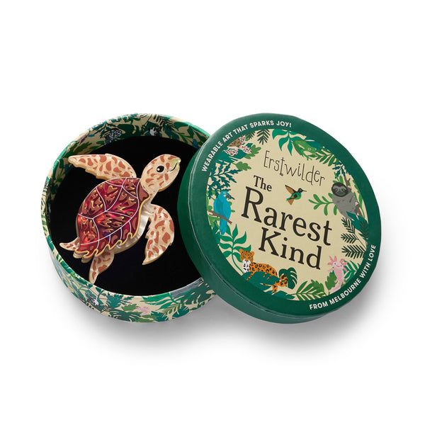 brown and tan sea turtle brooch shown in illustrated round box packaging