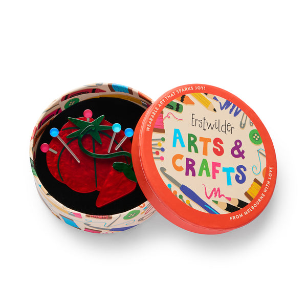 red tomato-shaped pin cushion with colorful ball-tipped pins acrylic resin brooch, shown in illustrated round box packaging
