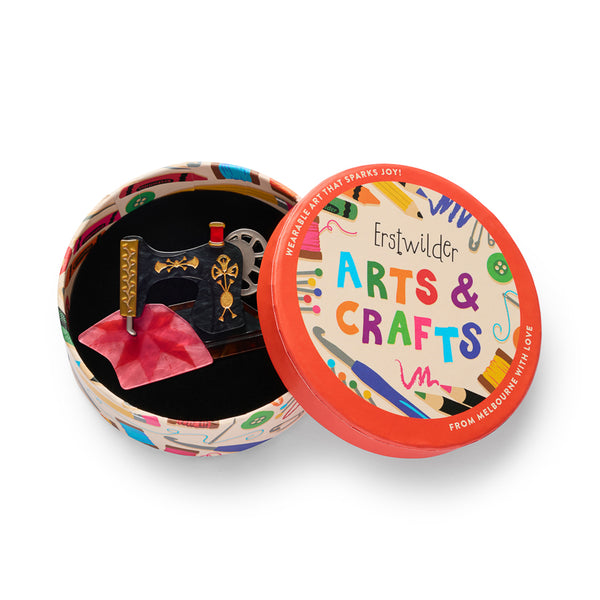 black sewing machine with pink fabric acrylic resin brooch, shown in illustrated round box packaging