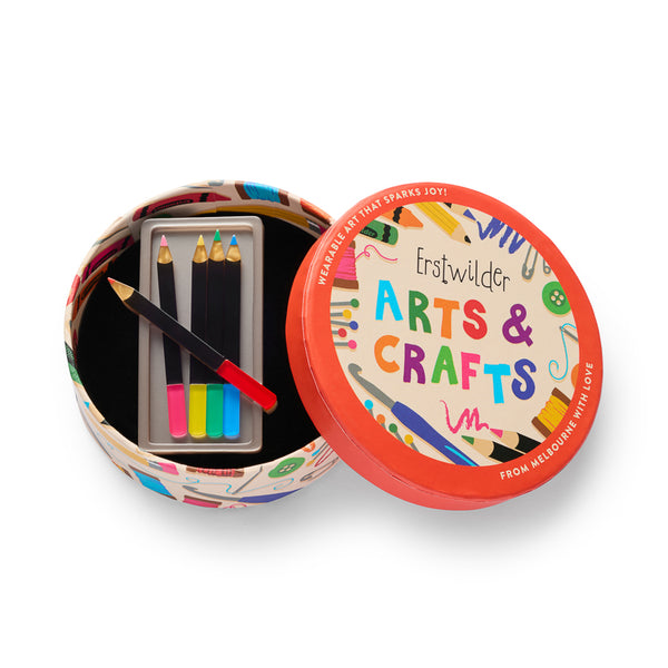 acrylic resin brooch in the shape of a metallic silver pencil box with five colored pencils, shown in illustrated round box packaging