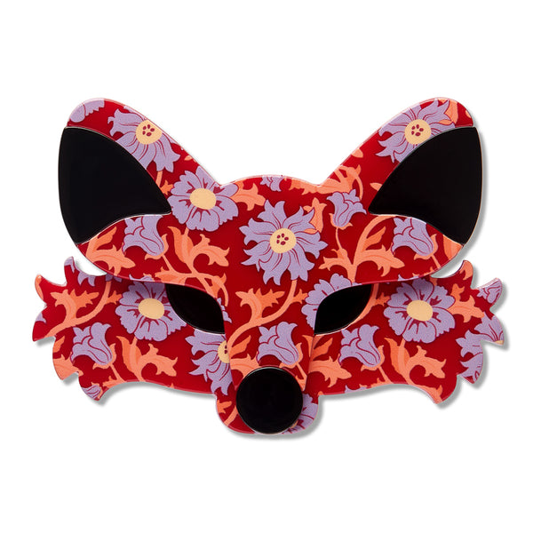 A fox face acrylic resin brooch with a red background and a floral pattern in lavender, orange, and purple, featuring solid black ear and nose areas, shown on a white background.