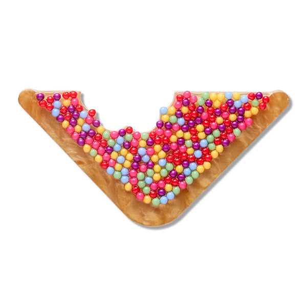 acrylic resin brooch of a triangular piece of bread covered in colorful sprinkles with a bit taken out of it