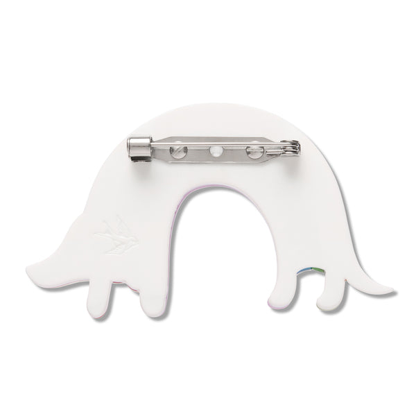 A white dog-shaped brooch pin with a silver metal pin clasp on a plain white background.