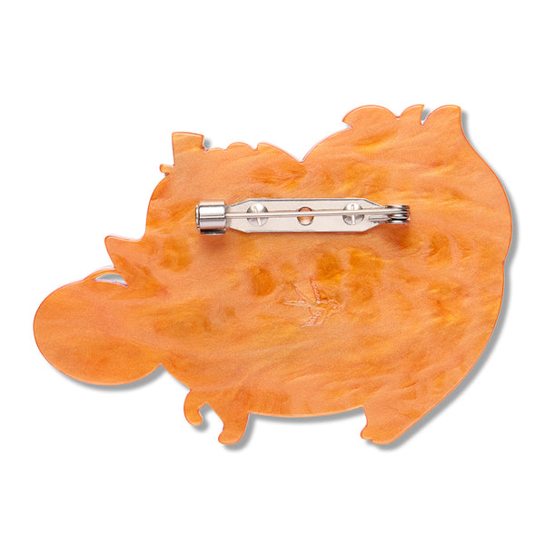 orange resin back layer of a fluffy dog-shaped brooch with silver metal pin clasp fastener