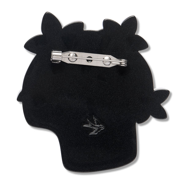 black resin back layer of a skull and flowers-shaped brooch with silver metal pin clasp fastener