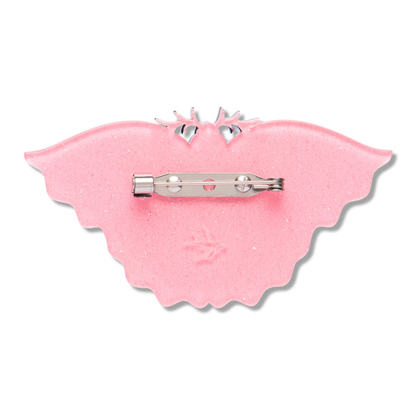 pink glitter resin back layer of a moth-shaped brooch with silver metal pin clasp fastener