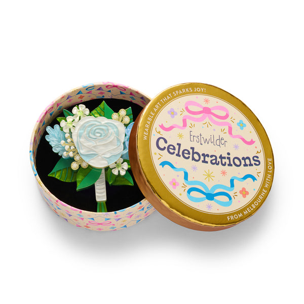 layered acrylic resin blue, creamy yellow, green, and white floral bouquet brooch, shown in illustrated round gift box packaging.