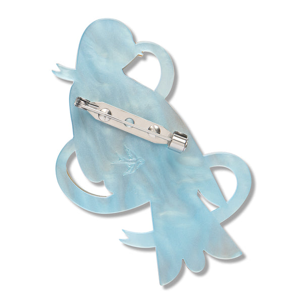 blue acrylic resin back layer of a dove and ribbon shaped brooch with silver metal pin clasp