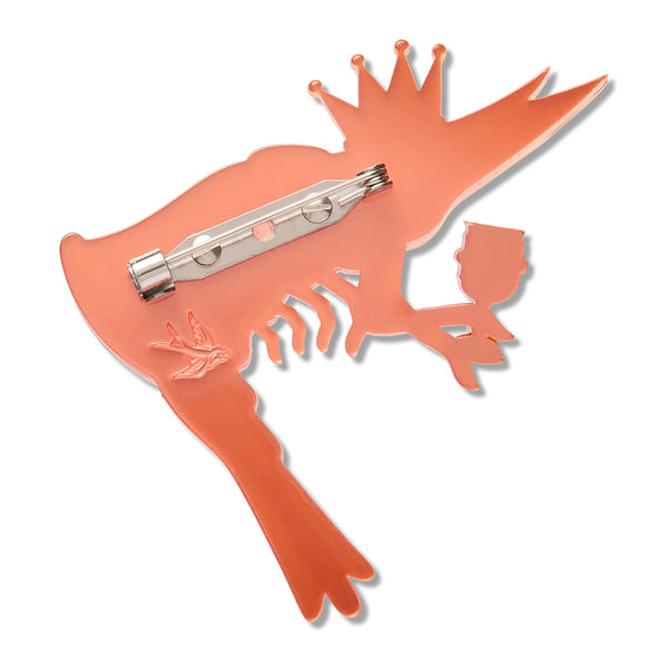 An orange-red resin shrimp-shaped pin with a silver-tone pin clasp on the back, shown against a plain white background.