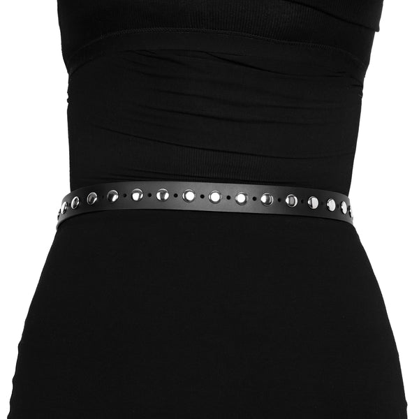 Model wearing black faux leather belt with silver metal buckle with matching keeper and top & single row of round flat metal studs. Punch holes alternate with studs for the entire length of the belt. Shown from back