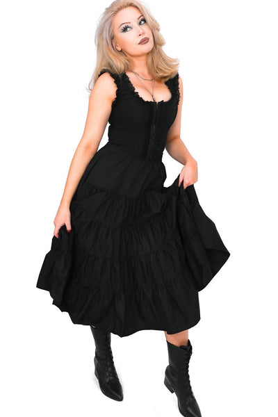Model wearing a black cotton poplin midi skirt with an elastic waistband and four tiered ruffled layers with side seam pockets. Shown from front