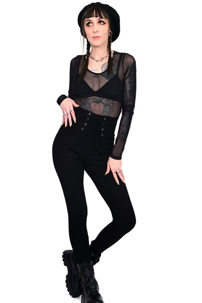 Model wearing black cotton modal blend leggings with high waistband and corset-style lace-up front detail. Shown from front
