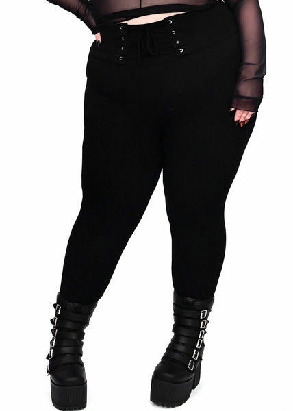 plus-size model wearing black cotton modal blend leggings with high waistband and corset-style lace-up front detail. Shown from front