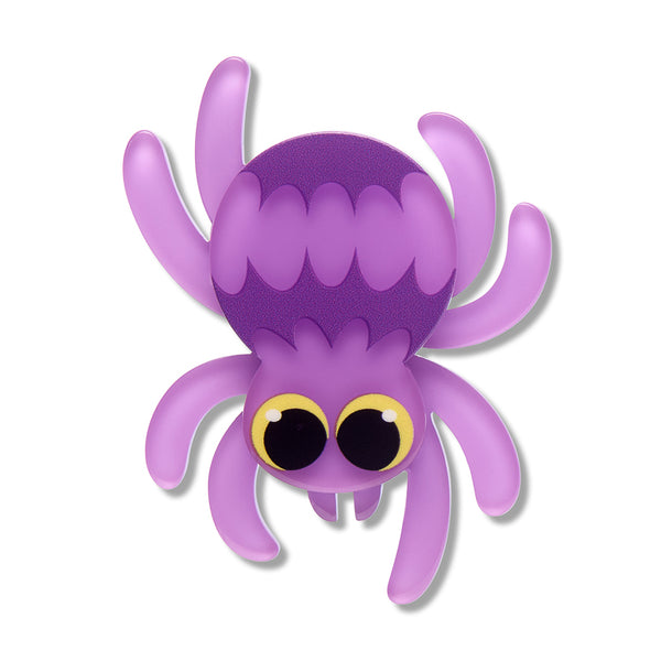 A cute cartoon spider acrylic resin brooch in shades of purple with large round black and yellow eyes, isolated on a white background.