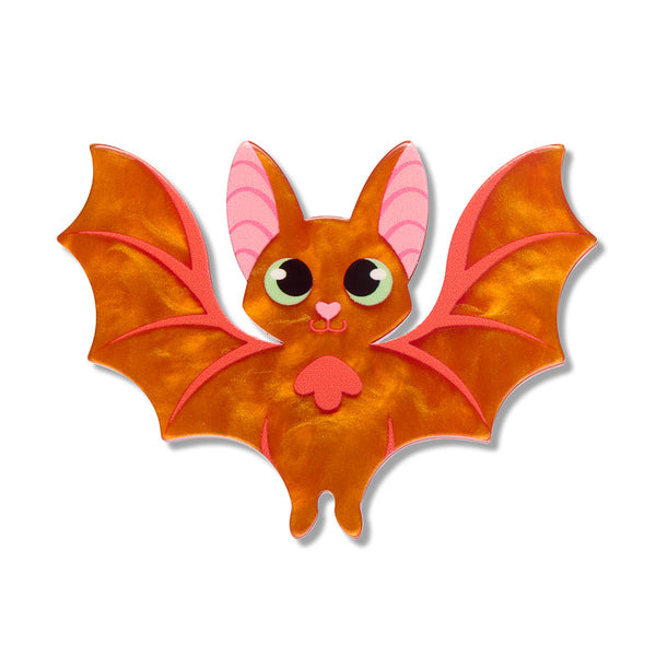 A cute cartoon bat acrylic resin brooch with orange wings and body, pink inner ears, and large green-ringed eyes, shown on a plain white background.