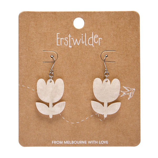 white flower-shaped earrings on a brown card with 'Erstwilder' branding.