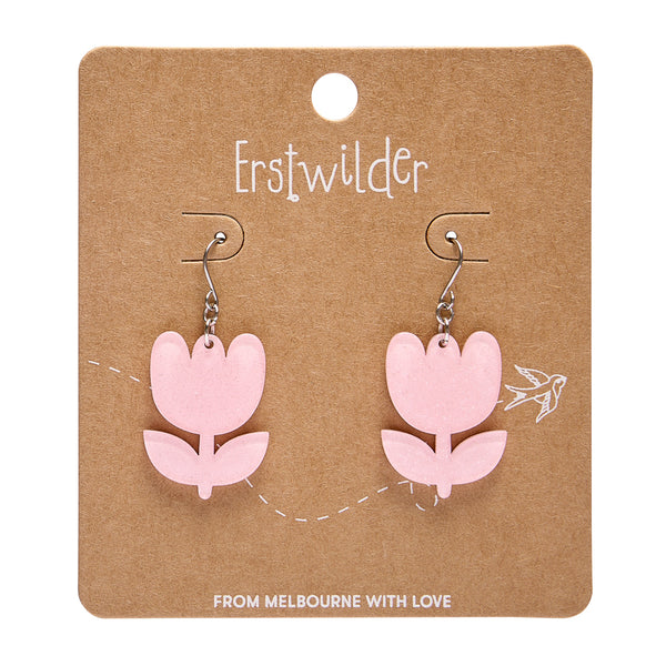 Pink flower-shaped earrings on a brown card with 'Erstwilder' branding.