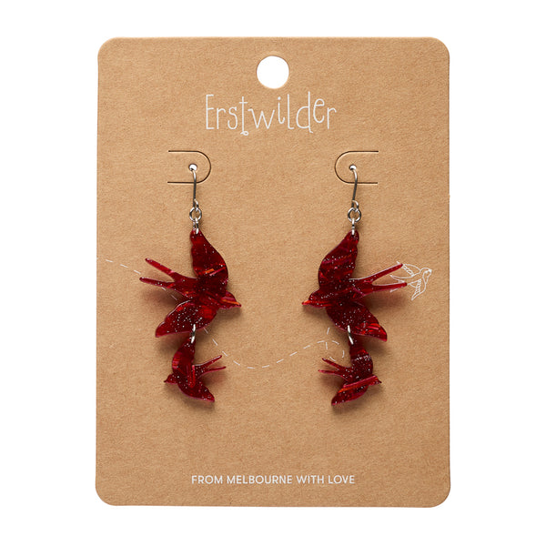 Red bird-shaped earrings on a brown card with 'Erstwilder' branding.