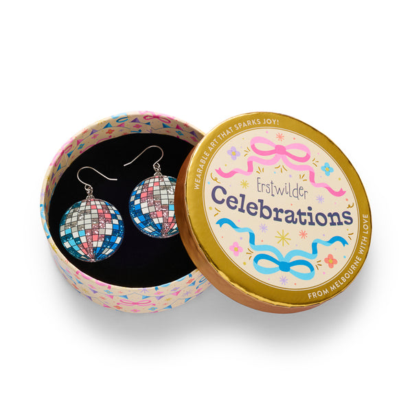 A pair of silver-tone fishhook drop earrings featuring acrylic resin round disco ball shaped charms with a mosaic pattern of blue, pink, white, and glittery silver squares. Shown in illustrated round gift box packaging.