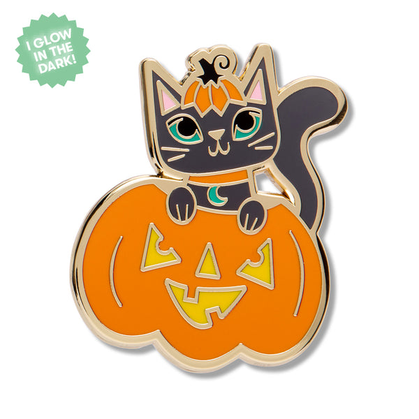 A gold metal enamel pin featuring a cartoon black cat wearing an orange pumpkin top as a hat and sitting in a jack-o'-lantern