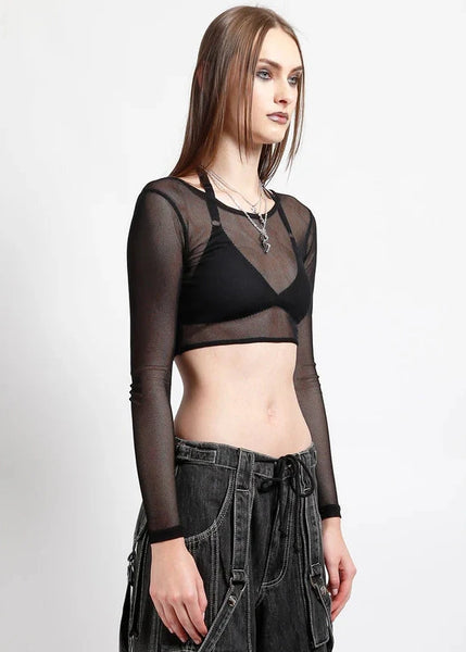 Model wearing a black sheer long-sleeve fishnet crop top and dark jeans on a white background. Shown from side