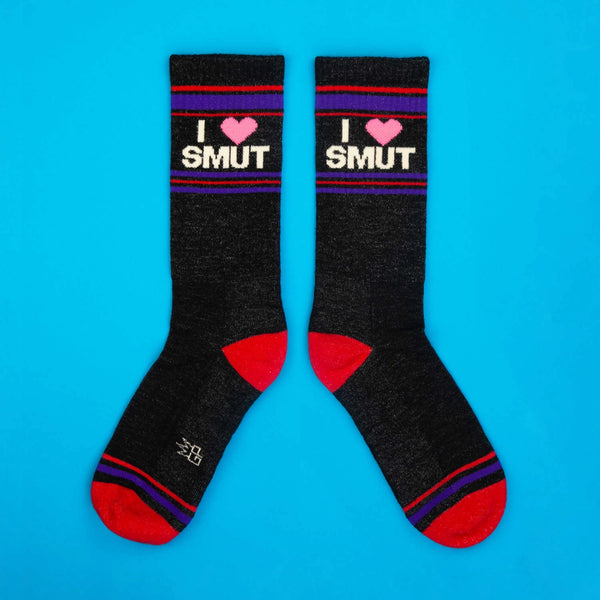 “I ❤️ SMUT” heathered black gym style socks with red and purple stripes at the cuffs, toes, and heels. Shown on blue background