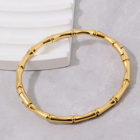 Gold finish stainless steel hinge bamboo style bangle shown flat