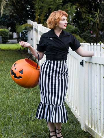 Model wearing a high-waisted cotton pencil skirt with a vertical black and white striped pattern. The bottom of the skirt ends in a ruffled mermaid style hem