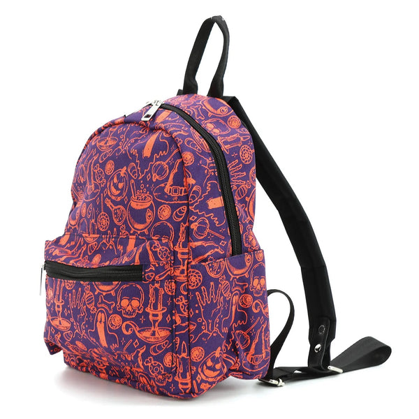 A mini backpack with a witchy themed pattern of bubbling cauldrons, ghosts, vials of mysterious liquids, pointy hats, candles, and child-enticing pieces of candy in orange on a purple background. Seen from a 3/4 angle