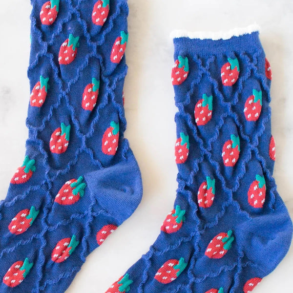 cotton knit socks in blue with a textured knit-in pattern of red strawberries and a matching wavy diamond pattern. Shown in close up