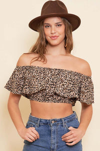 A model wearing an off the shoulder ruffled crop top in a leopard print pattern. Made of a lightweight crepe woven material 