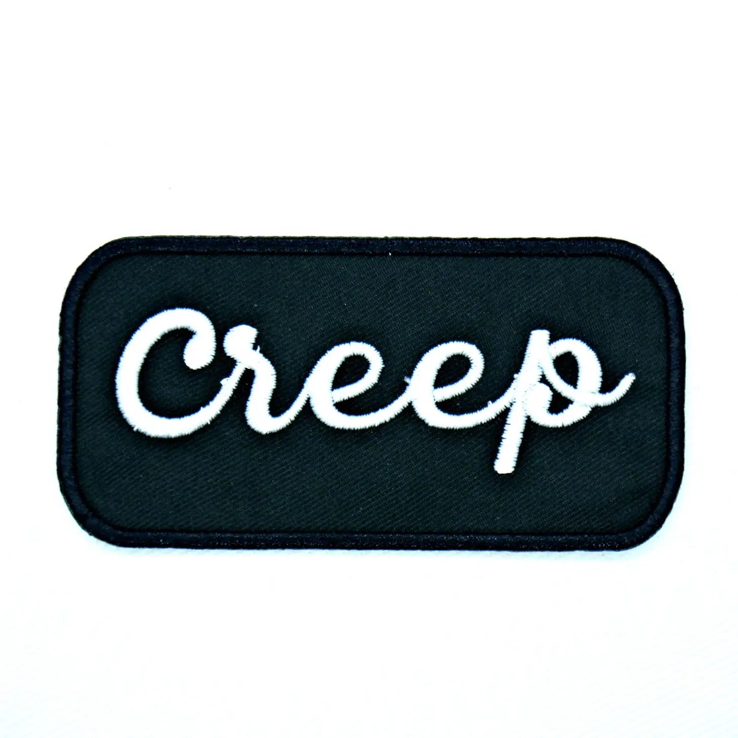 Black & white "Creep” cursive name tag style embroidered patch. Black background with white lettering 