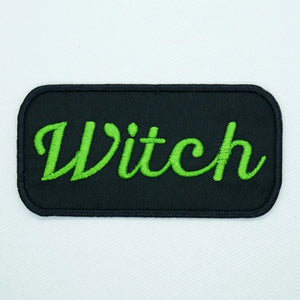 Black & green "Witch” cursive name tag style embroidered patch. Black background with green font