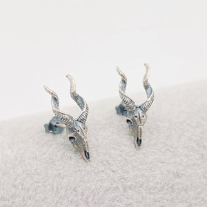 tiny, highly detailed burnished sterling silver goat head skull post earrings. Shown from front 