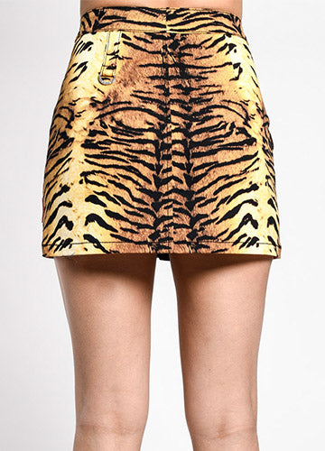 Cotton stretch twill mini skirt in an all-over black, orange, and yellow tiger print. It has a double snap closure at the waistband and a heavy duty silver metal zipper down the front. There is a matching fabric tab with silver metal D-ring on the left hip of the front and back of the skirt. Seen on a model from the back 